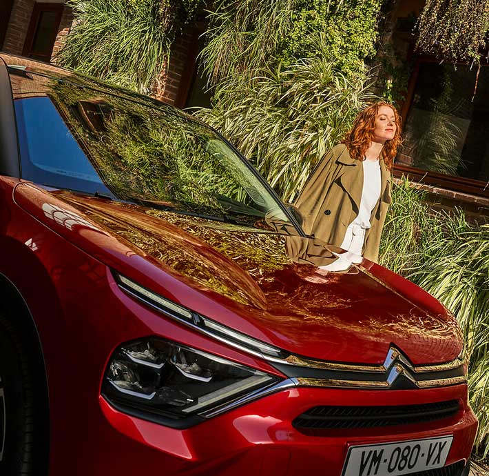 femme à côté d'une voiture electrique Ë-C4