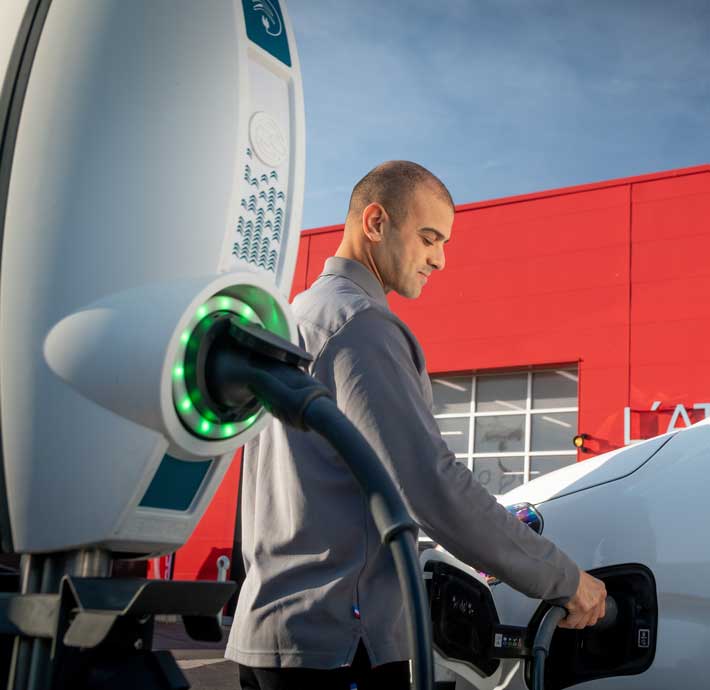 personne qui recharge un vehicule electrique