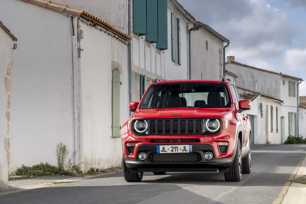 SUV Jeep Renegade rouge se démarquant dans les rues historiques de Valence, Drôme Ardèche, incarnant le parfait équilibre entre style urbain et esprit aventurier.