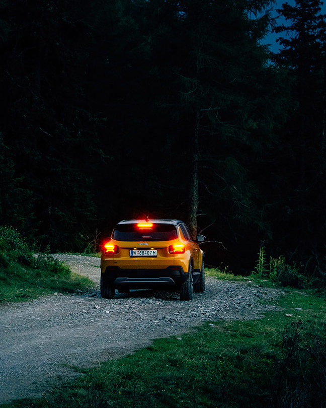 SUV Jeep Avenger en conduite nocturne sur un chemin tout-terrain, mettant en avant sa robustesse et ses capacités tout-terrain