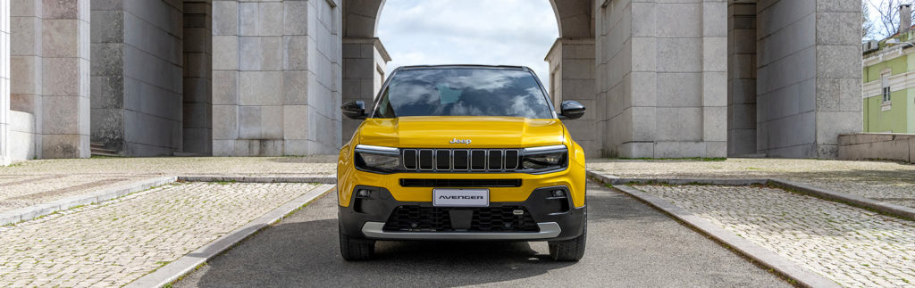 Jeep Avenger jaune devant un monument, illustrant un SUV performant, compact et urbain.