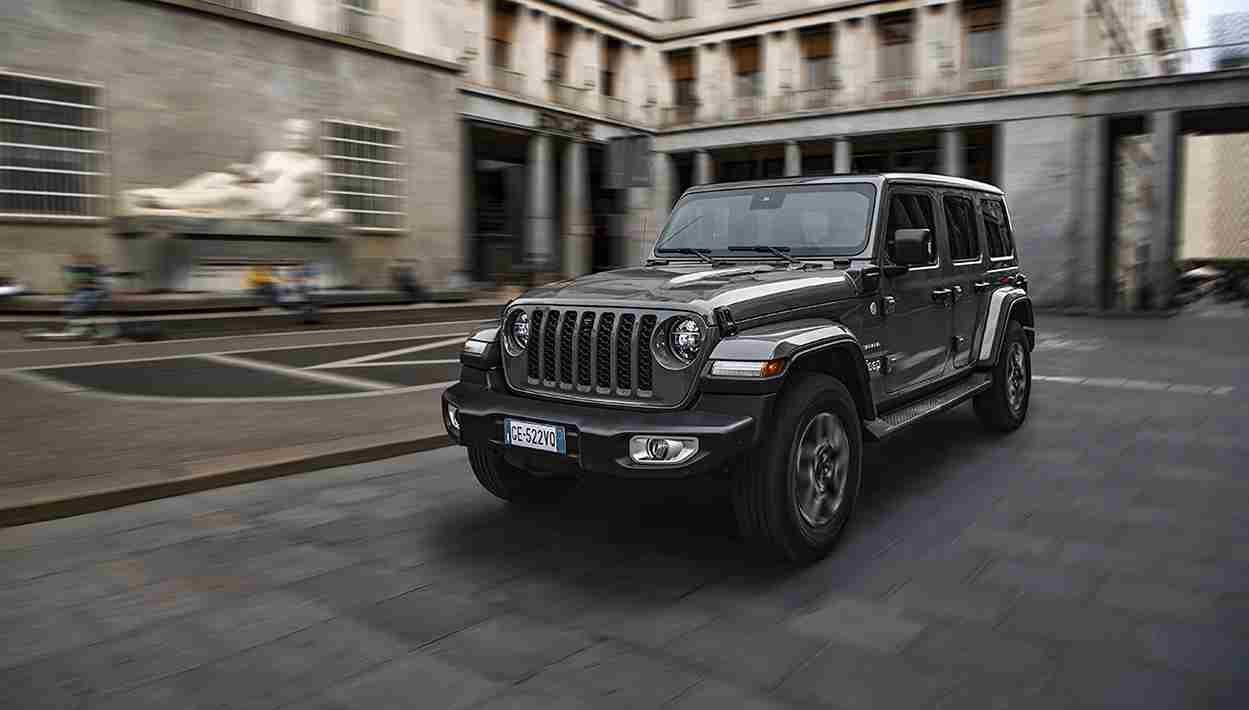 SUV Jeep Wrangler 4xe Sahara gris circulant en ville, mettant en avant son design distinctif et sa robustesse, idéal pour les aventures tout-terrain et les trajets urbains à Valence, Drôme-Ardèche.
