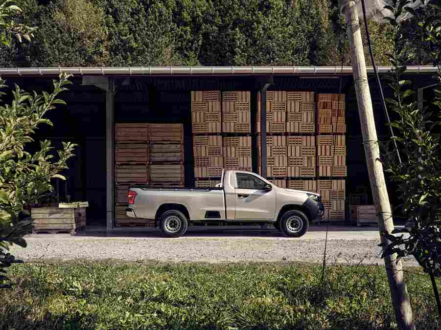Utilitaire Peugeot Landtrek d'occasion garé devant un entrepôt de caisses en bois, illustrant sa capacité de chargement et sa robustesse, disponible à Valence, Drôme-Ardèche.