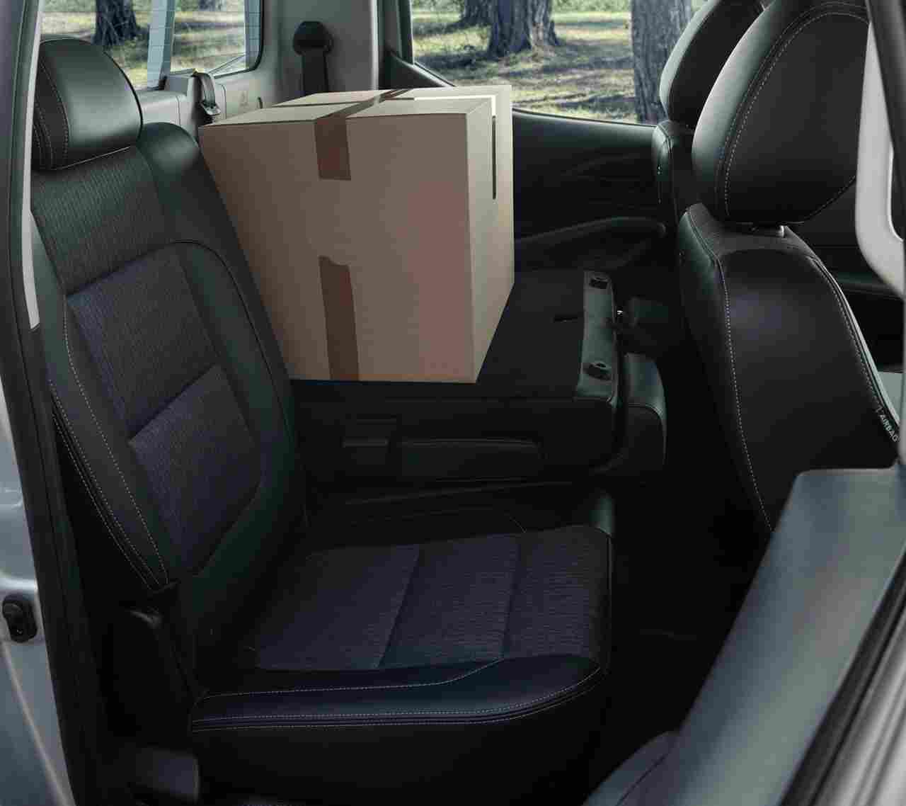  Intérieur d'un utilitaire d'occasion à Valence, montrant un espace de rangement pratique avec un carton sur le siège arrière, idéal pour un usage polyvalent.